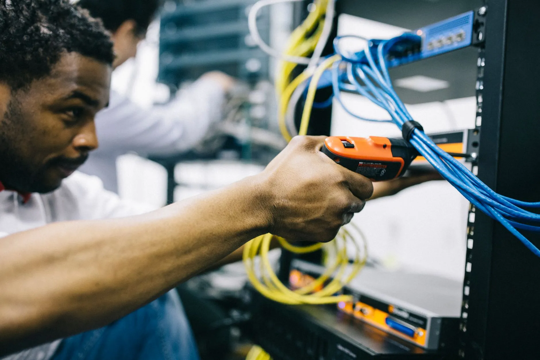 Technician troubleshooting server hardware and network cables in a data center
